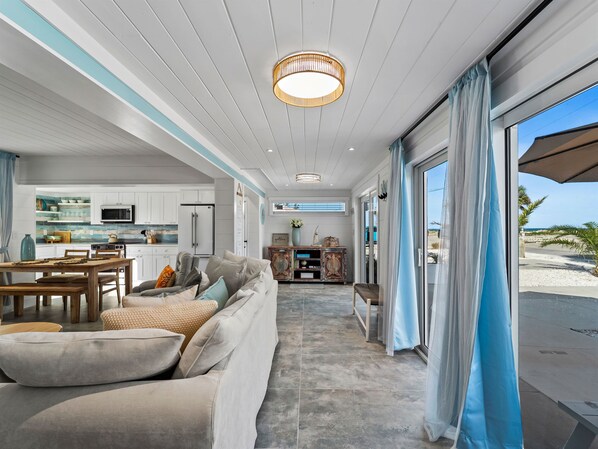 A modern interior with a kitchen, dining area, and a view to the outside.