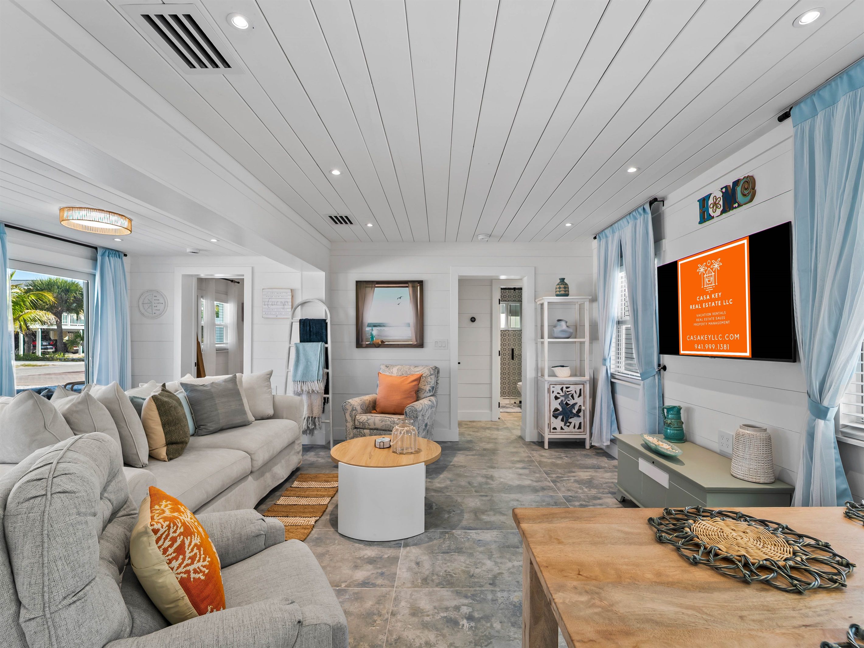 A modern living room with a sofa, coffee table, and a TV mounted on the wall.