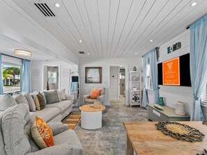 A modern living room with a sofa, coffee table, and a TV mounted on the wall.