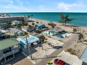 A coastal area with buildings, a beach, and a clear view of the ocean.
