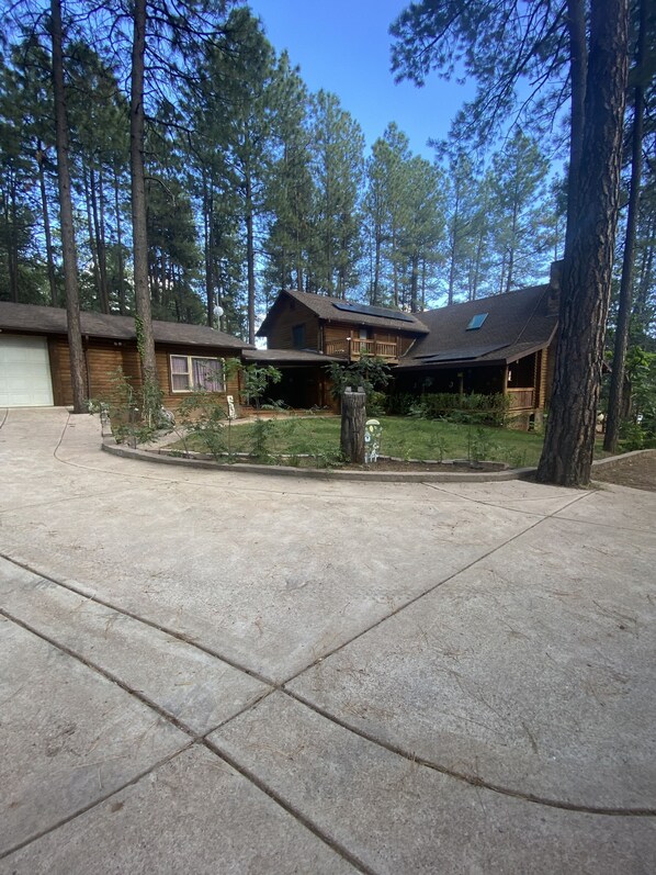 A two-story log cabin with a covered porch and a garage. - Private Mountain True Log Cabin Retreat with 2 Master Bedrooms (Strawberry)