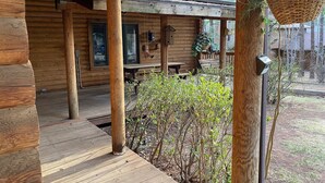 A wooden cabin with a porch, a hanging plant, and a bench. - Private Mountain True Log Cabin Retreat with 2 Master Bedrooms (Strawberry)