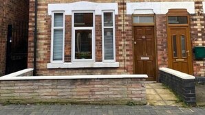 A two-story brick house with a front door, two windows with shutters, and a small porch. - Perfect for contractors, 4-bedrooms, sleeps 7! (Crewe)