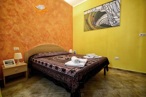 Une chambre à coucher avec un lit, une table de chevet, une lampe et un tableau au mur.