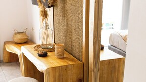 A wooden desk with a bowl of stones, a vase, and a woven basket. - Casa Blue Marine (Skiathos)