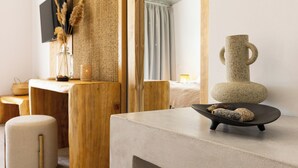 A modern room with a wooden desk, a stone vase, and a small stool. - Casa Blue Marine (Skiathos)