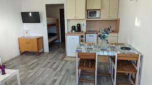 A compact kitchen with a microwave, coffee maker, and a small refrigerator.