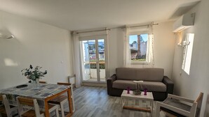 A compact living space with a dining area, a sofa, and a small table.