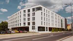 Un hotel moderno con fachada plana, múltiples ventanas y cielo despejado.