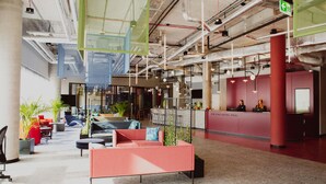 Un vestíbulo espacioso con asientos modernos, una recepción y señalización clara del hotel.
