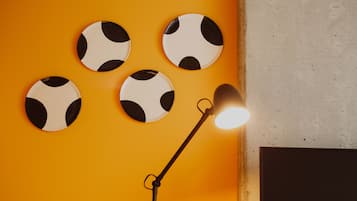 Ett rum med en gul vägg, en lampa och fyra fotbollsformade dekorationer.