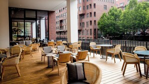 Een terras met rieten meubels en een houten terras.