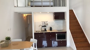A compact kitchen with a dining area, a staircase, and a small seating space. - APPART NOE - rue Carreterie - 4 pers. (Avignon)