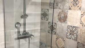A glass-enclosed shower stall with a handheld showerhead and a fixed showerhead. - APPART NOE - rue Carreterie - 4 pers. (Avignon)