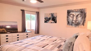 A bedroom with a bed, a dresser, a window with curtains, and two wall art pieces. - Condo *Zen* King N. Phoenix 30 (Phoenix)