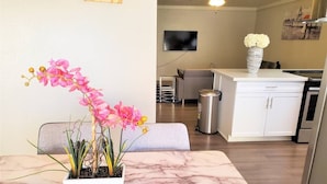 A modern kitchen with white cabinetry, a marble countertop, and a potted orchid plant. - Condo *Zen* King N. Phoenix 30 (Phoenix)