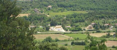 A rural landscape with scattered buildings, fields, and dense forested areas.