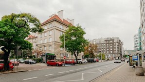 Una calle con coches estacionados, árboles y edificios de varios pisos.
