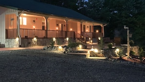 A two-story house with a porch, stone foundation, and a gravel driveway. - Secluded home on 24 acres (Hayesville)