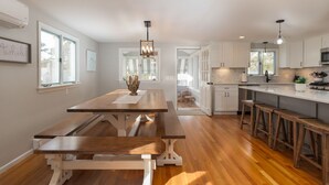 A modern kitchen with wooden countertops, a central island, and bar stools.