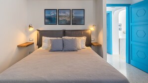 Una camera da letto con un letto, due lampade a parete e tre quadri appesi sopra il letto.