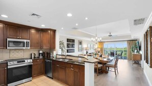 Una cocina moderna con armarios de madera, horno empotrado y una isla grande con pileta.