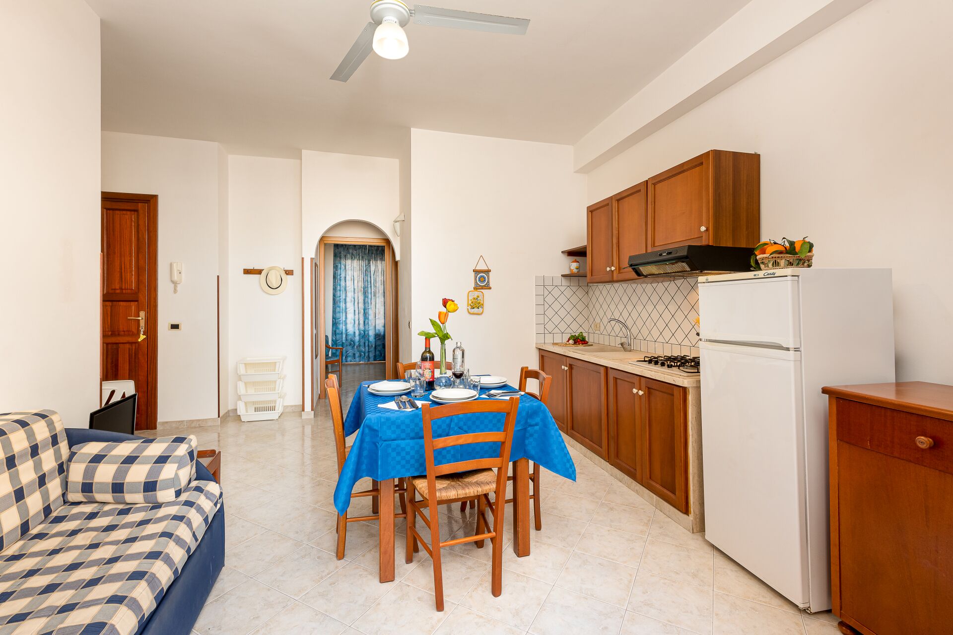 A compact living space with a dining area, kitchenette, and a sofa.