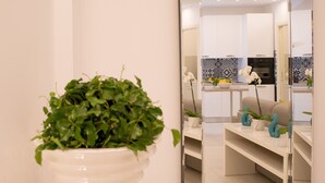 Een moderne keuken met witte kasten, een zwarte oven en een betegelde spatwand.