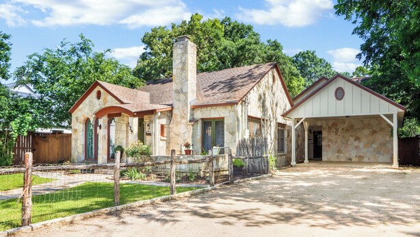 A rustic stone building with a chimney, a fenced yard, and a covered garage. - Cozy & Convenient, 1/2 block off Main St. in Boerne, WALK EVERYWHERE! (Boerne)