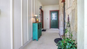 A hallway with a teal cabinet, a lamp, a door, and a climbing plant. - Cozy & Convenient, 1/2 block off Main St. in Boerne, WALK EVERYWHERE! (Boerne)