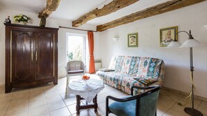 A living room with a wooden ceiling, a sofa, a table with a bowl, a cabinet, and a floor lamp. - Appartement "kerouac", Maison du 18ème Avec Wifi, Proche des Plages de Sable fin (Carnac)