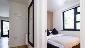 A bedroom with a bed, a window, and a wall with a welcome sign. - 15% OFF Superhost Stays Mn-Fri | Spacious 2 Bd Apt (Cardiff)