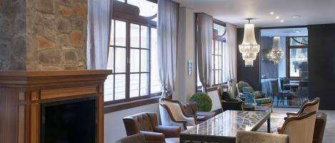 A modern dining area with a fireplace, large windows, and contemporary furniture.