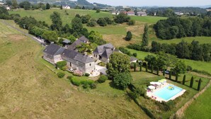 Vista aerea di una grande proprietà con diversi edifici, una piscina e giardini curati.