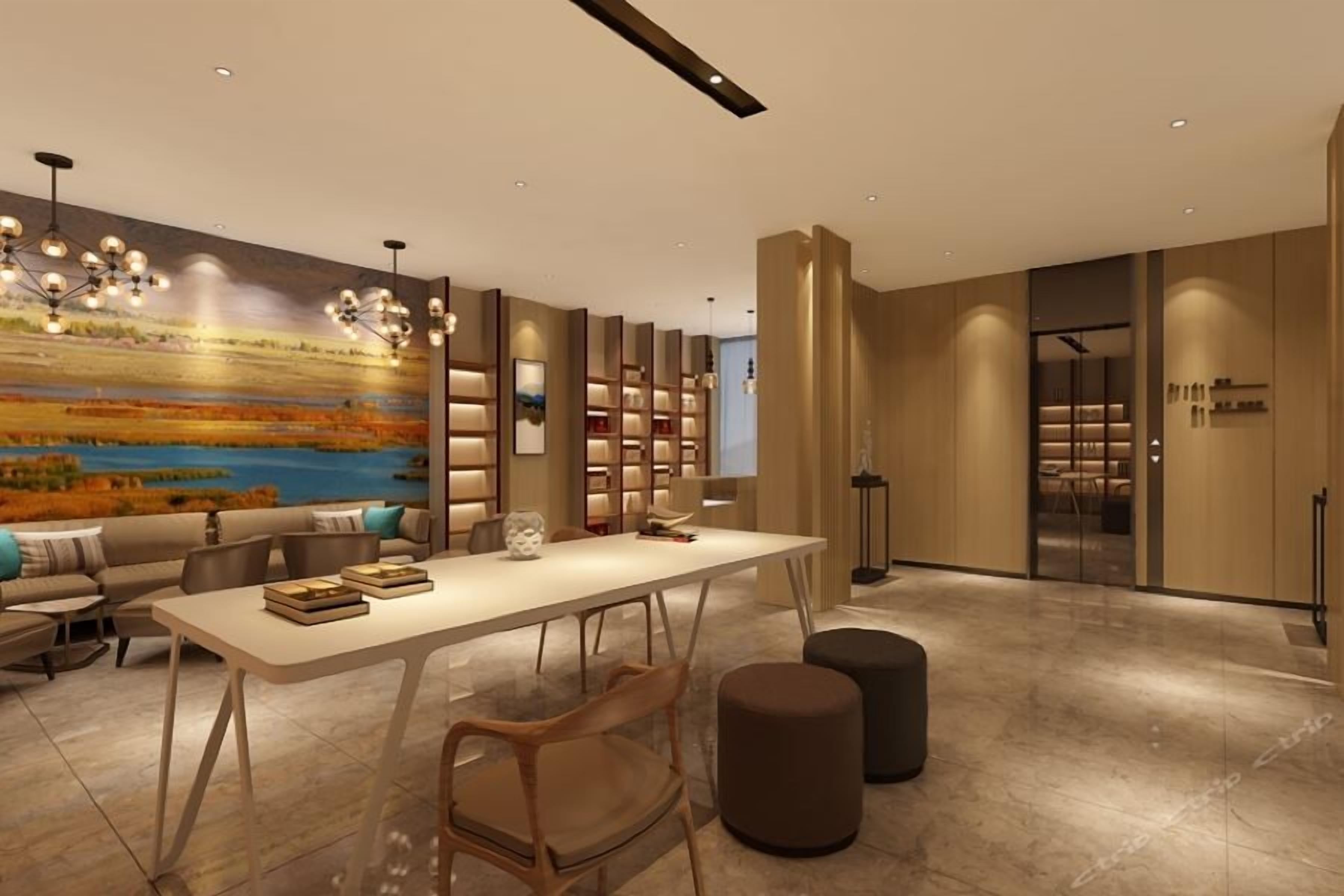 A modern interior with a dining area, bookshelves, and a large painting on the wall.