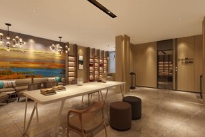 A modern interior with a dining area, bookshelves, and a large painting on the wall. - Atour Hotel (Lhasa)