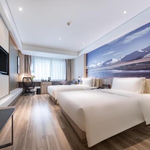 A hotel room with a large bed, a desk, a chair, a TV, and a scenic wall mural. - Atour Hotel (Lhasa)