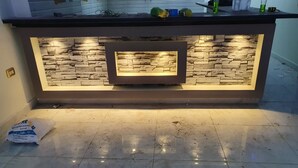 A kitchen with a built-in island featuring a stone backsplash and under-cabinet lighting. - Lovely 3-bed Pyramids Viewapartment in Kafr Nassar (Giza)