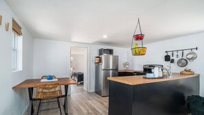 Una cocina compacta con una isla central, un refrigerador y un microondas.