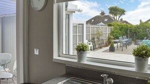 Een keuken met een raam, spoelbak en potplanten.
