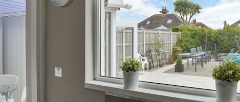 A kitchen with a window, sink, and potted plants.