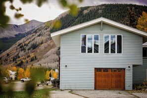 A single-story house with a garage, a satellite dish, and a view of a mountainous landscape. - Large Home in Crested Butte | 5 Bedroom | Game Room | Rainbow Park | Mt CB View (Crested Butte)