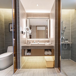 Ein modernes Badezimmer mit großem Spiegel, Waschbecken, Toilette und Dusche.