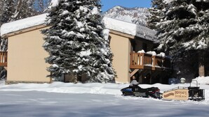 A snow-covered building with a ski lift and a snowmobile parked in front. - Best Deal, small 2 bedroom unit (Ketchum)