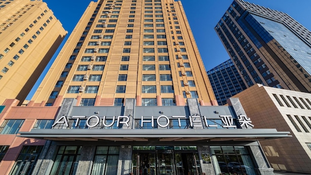 A hotel with a modern facade, large windows, and a prominent entrance. - Atour Hotel (Changchun)
