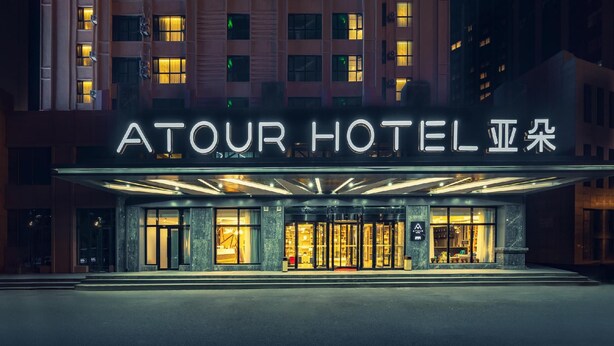 Entrada d'hotel amb façana moderna, senyalització il·luminada i porta d'entrada de vidre.