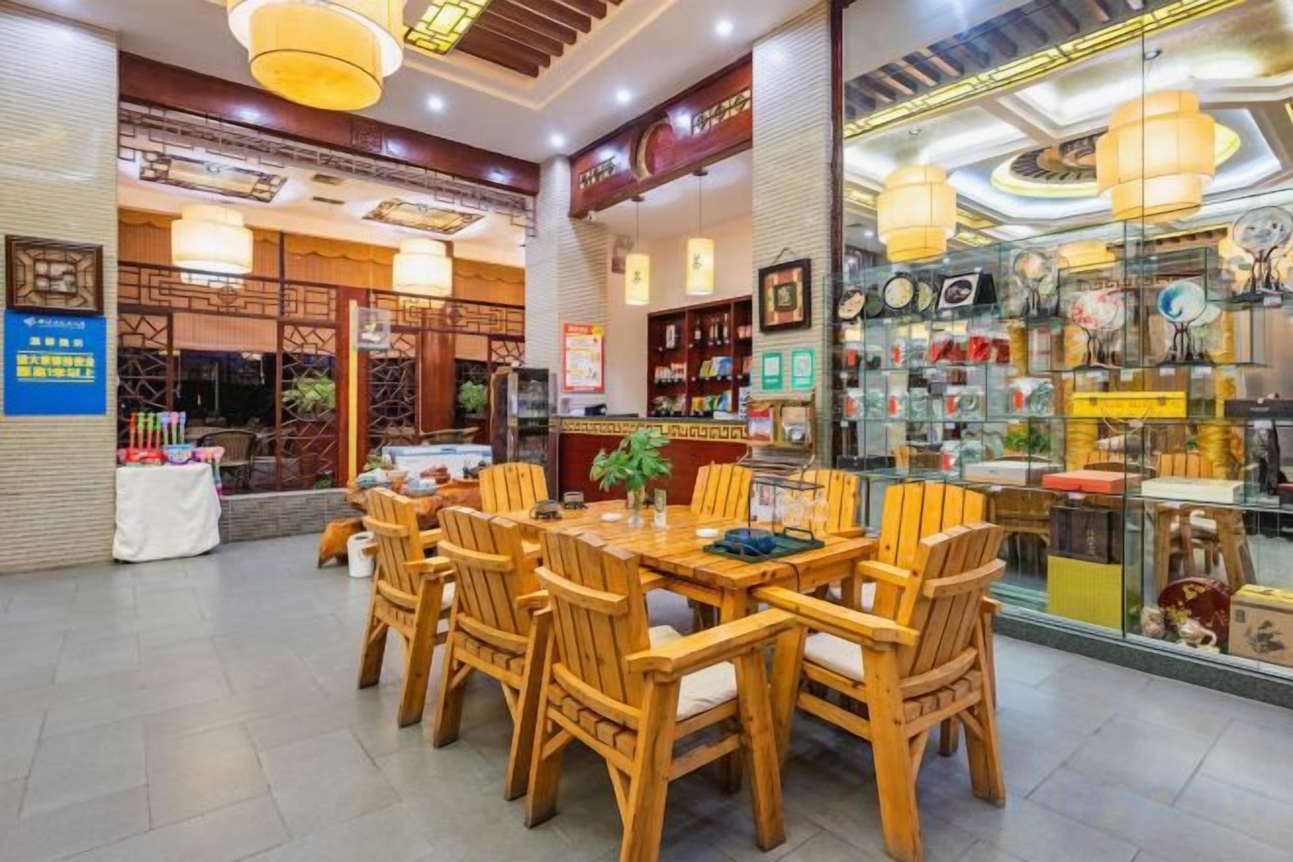 Un espace repas avec des tables et des chaises en bois, une vitrine exposant divers objets et une décoration intérieure de style traditionnel.