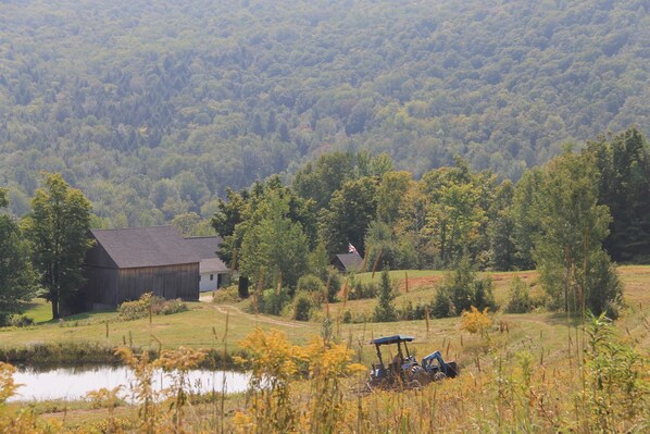 A rural landscape with a barn, a small house, and a tractor in the foreground. - Historic Schoolhouse in Rural Vermont Beauty Spot (Braintree)