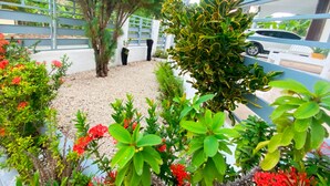Ein Balkon mit Kiesfläche, umgeben von verschiedenen Pflanzen und Blumen.