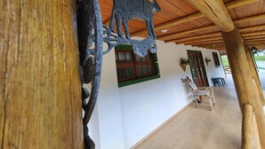 A wooden ceiling with a rustic design, a white wall with a window and a door, and a tiled floor. - Sítio Pedacinho do Céu na Serra de SC (Aguas Mornas)